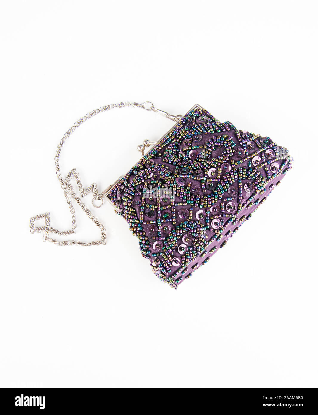 Purple beaded clutch purse fashion isolated on light background.  Silver chain strap with iridescent sequins and details.  Womens fashion accessory. Stock Photo