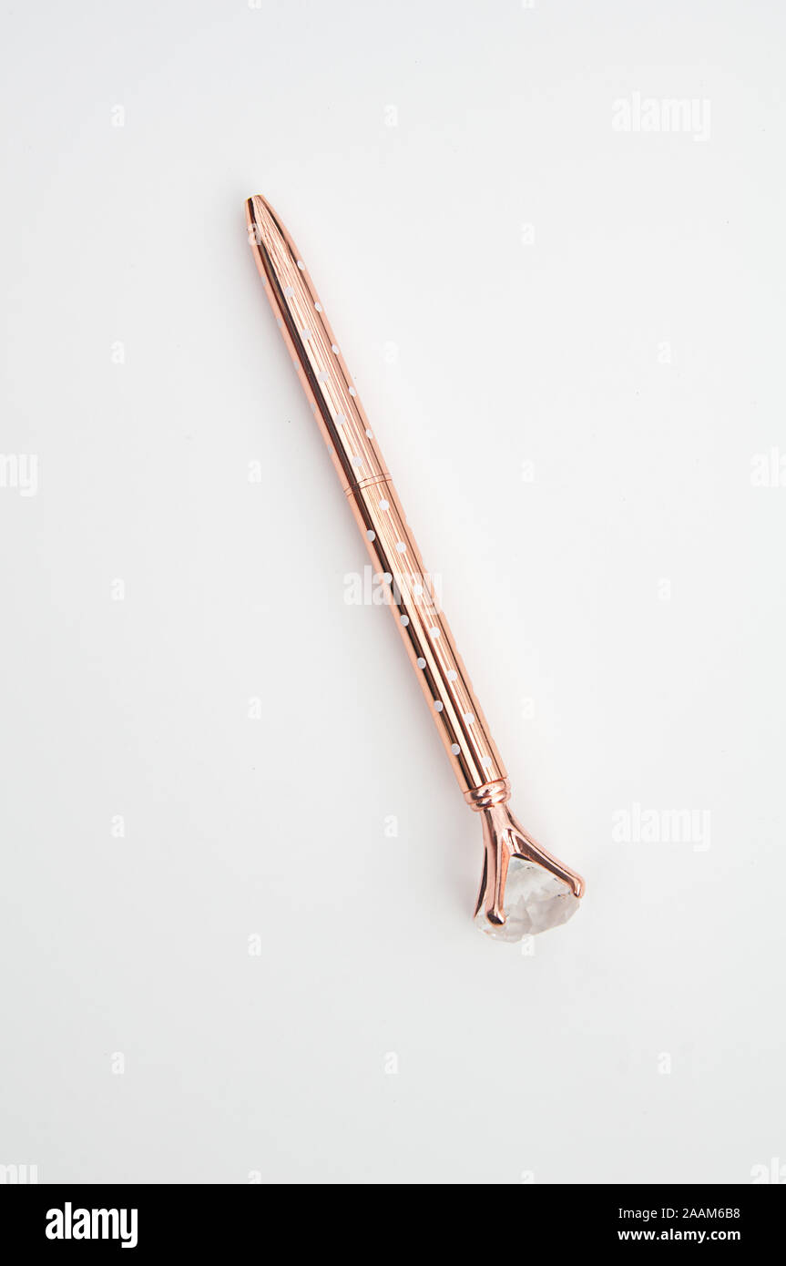 Rose gold pen isolated on light background. Writing instrument has