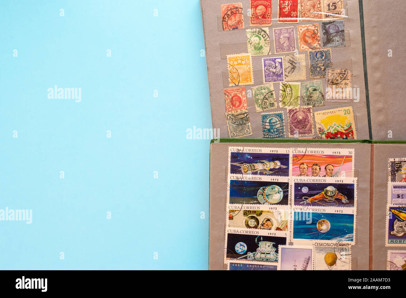 Stamp collecting. Two albums with old expensive valuable post stamps on blue background. Stock Photo