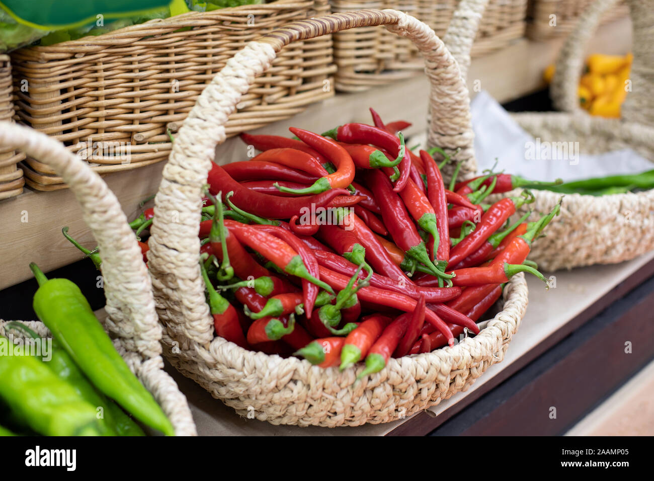 Wicker basket with a bunch of red hot chili peppers. Ripe spice ...