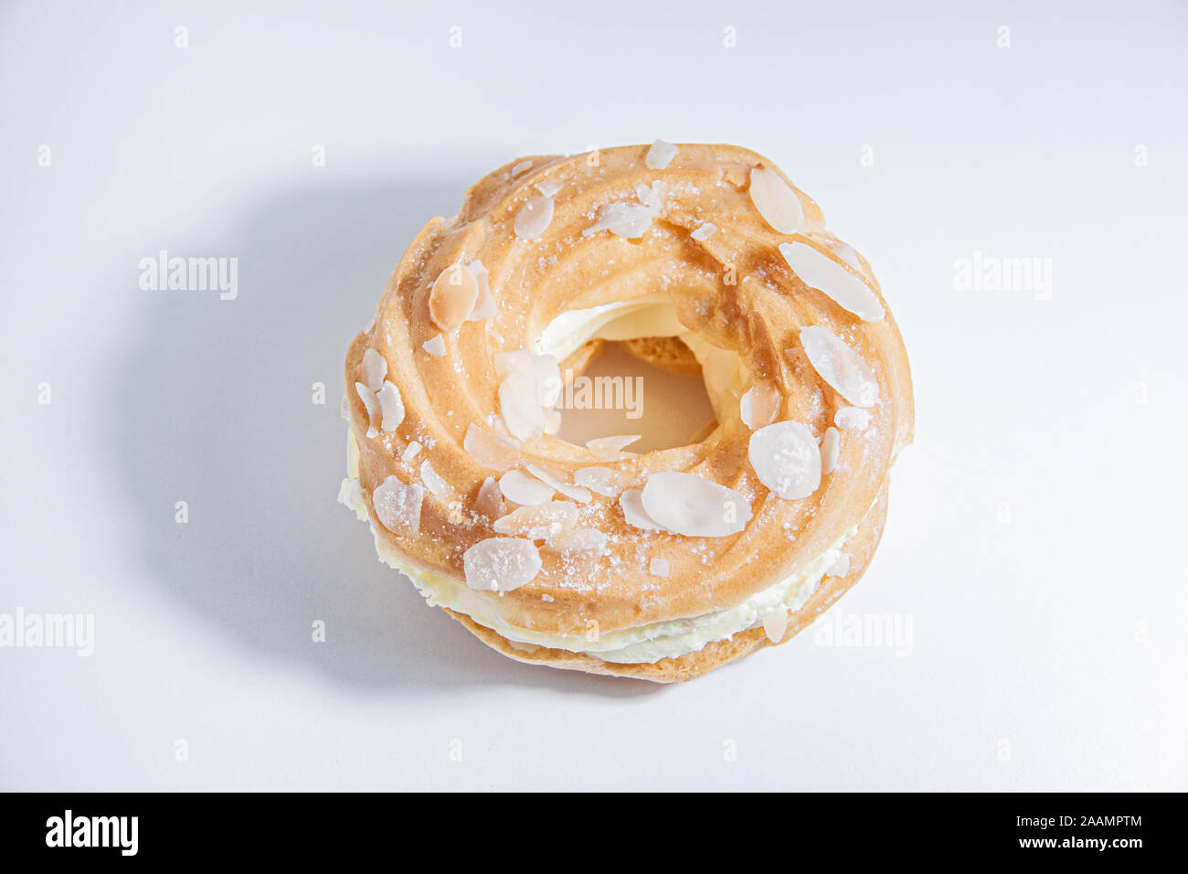 Top view of ring donut cut in the middle and inside whipped cream and on  the top almond slices and sugar puder on white background and shadow Stock  Photo - Alamy