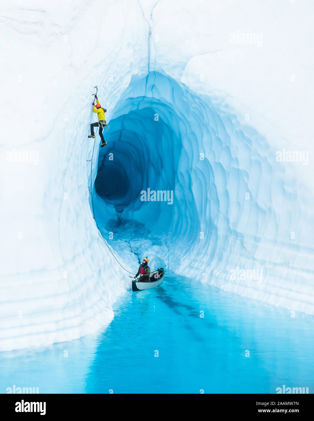 Don't Pop the Boat! - An ice climber leading up from inflatable canoe in a glacier lake on the Matanuska Glacier in Alaska. Stock Photo