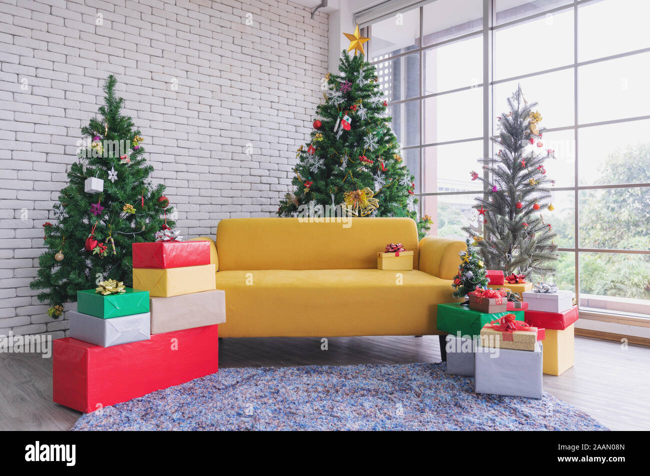 Christmas living room, Yellow sofa with Christmas trees and Christmas decorations Stock Photo