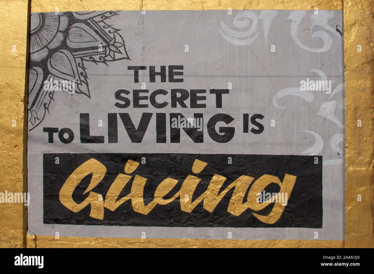 Ubud, Bali, Indonesia - 20th April 2019 : Beautiful mural art work with the quote 'The secret to living is giving' painted on a wall in the village of Stock Photo