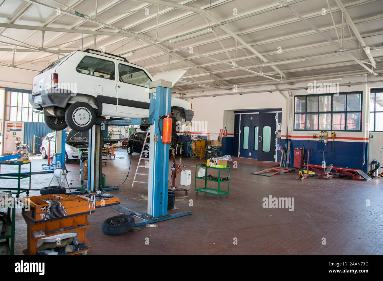 Lifted white car in a garage, Italy Stock Photo - Alamy