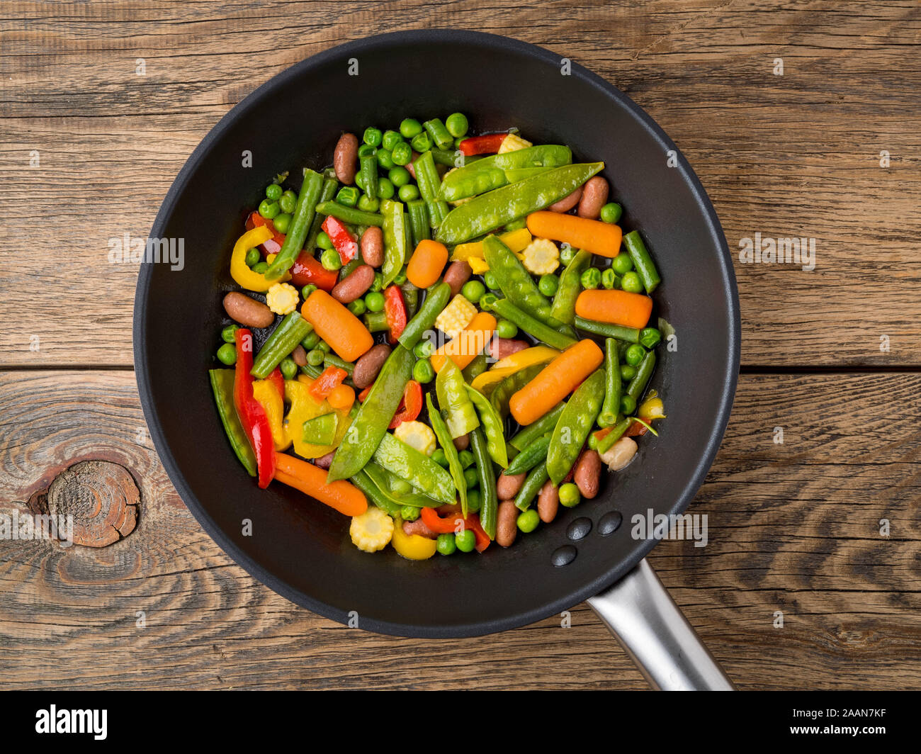 big pan fried with colorful vegetables peppers, peas, green beans