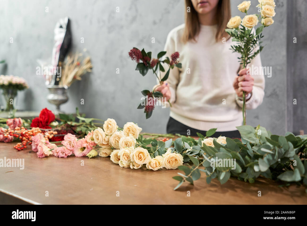 Step by step florist woman creates red beautiful bouquet of mixed flowers. Handsome fresh bunch. Education, master class and floristry courses Stock Photo