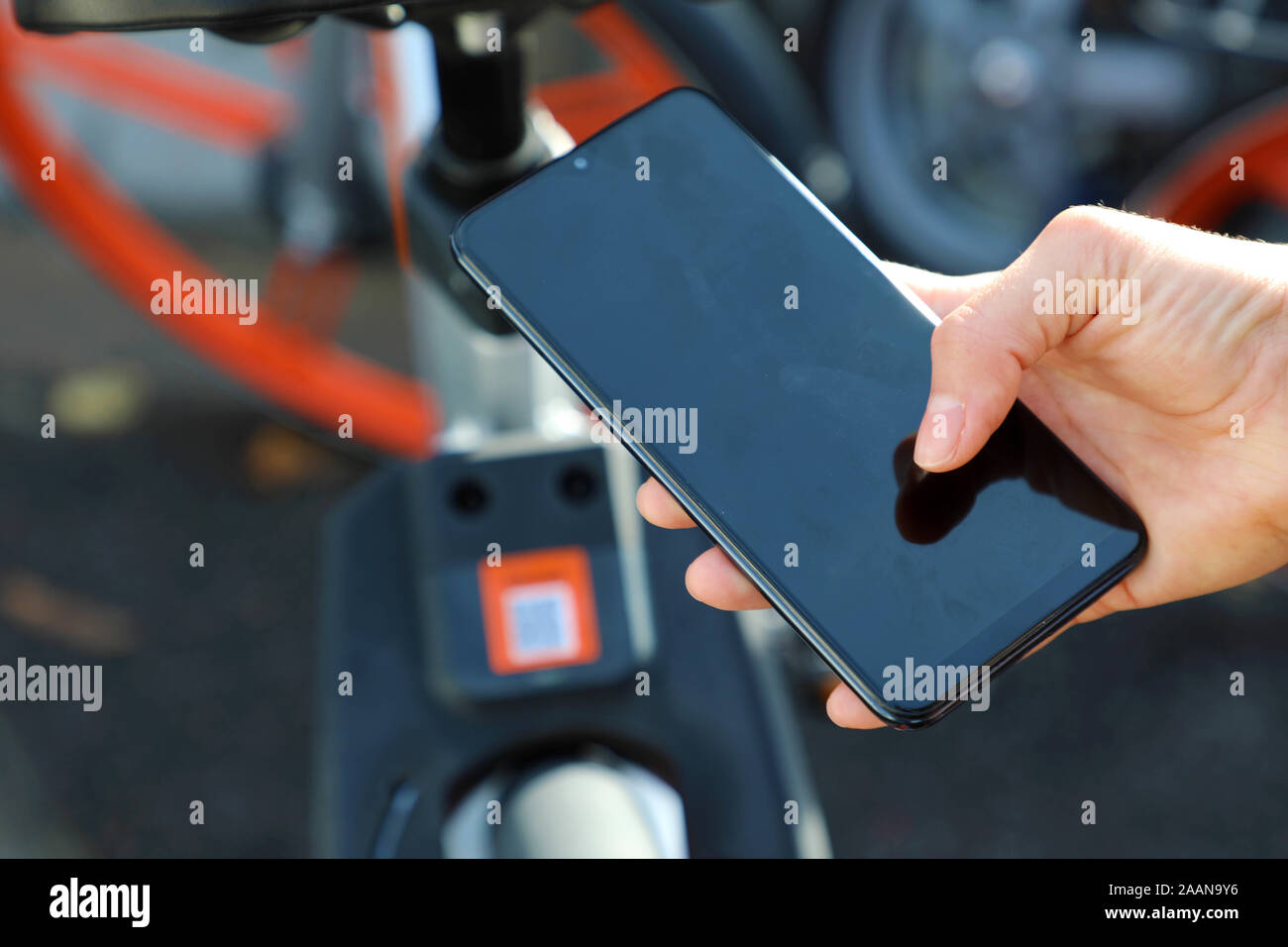 Shared bikes. Hand using smartphone scanning the QR code of shared bike