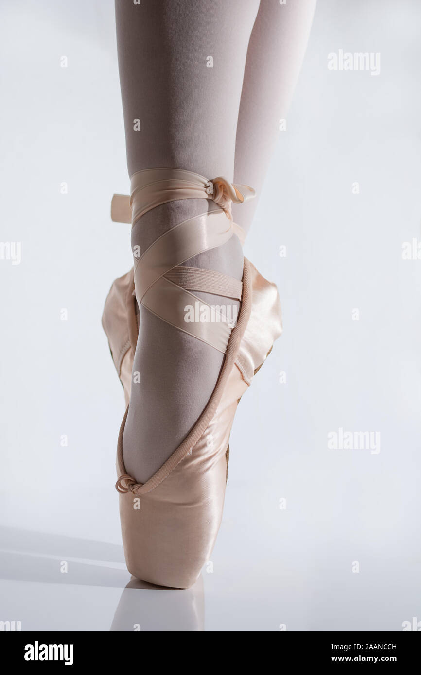 close-up of feet with pink satin pointe shoes by a classic ballerina on tiptoe Stock Photo
