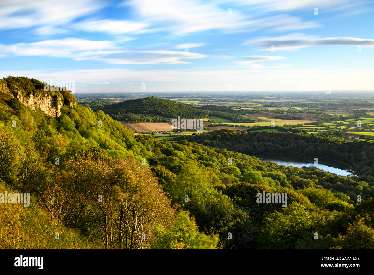 Beautiful scenic long-distance view (Lake Gormire, Hood Hill, Whitestone Cliff, countryside & blue sky) - Sutton Bank, North Yorkshire, England, UK. Stock Photo