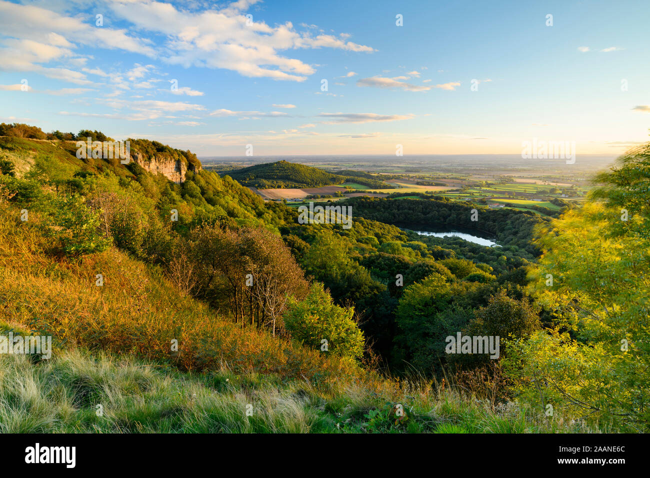 Beautiful scenic long-distance view (Lake Gormire, Hood Hill, Whitestone Cliff, countryside & blue sky) - Sutton Bank, North Yorkshire, England, UK. Stock Photo