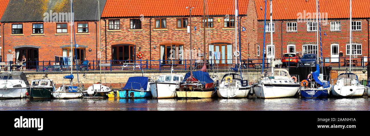 Small craft moored at Abraham's Quay on the East side of the River Esk at Whitby, North Yorkshire UK. The  houses are built on an old shipyard site close to Abraham's Bosom where the annual Penny Hedge or Horngarth traditional ceremony is performed on the eve of Ascension Day (40th day after Easter Sunday) , on the east bank of the River Esk . Stock Photo