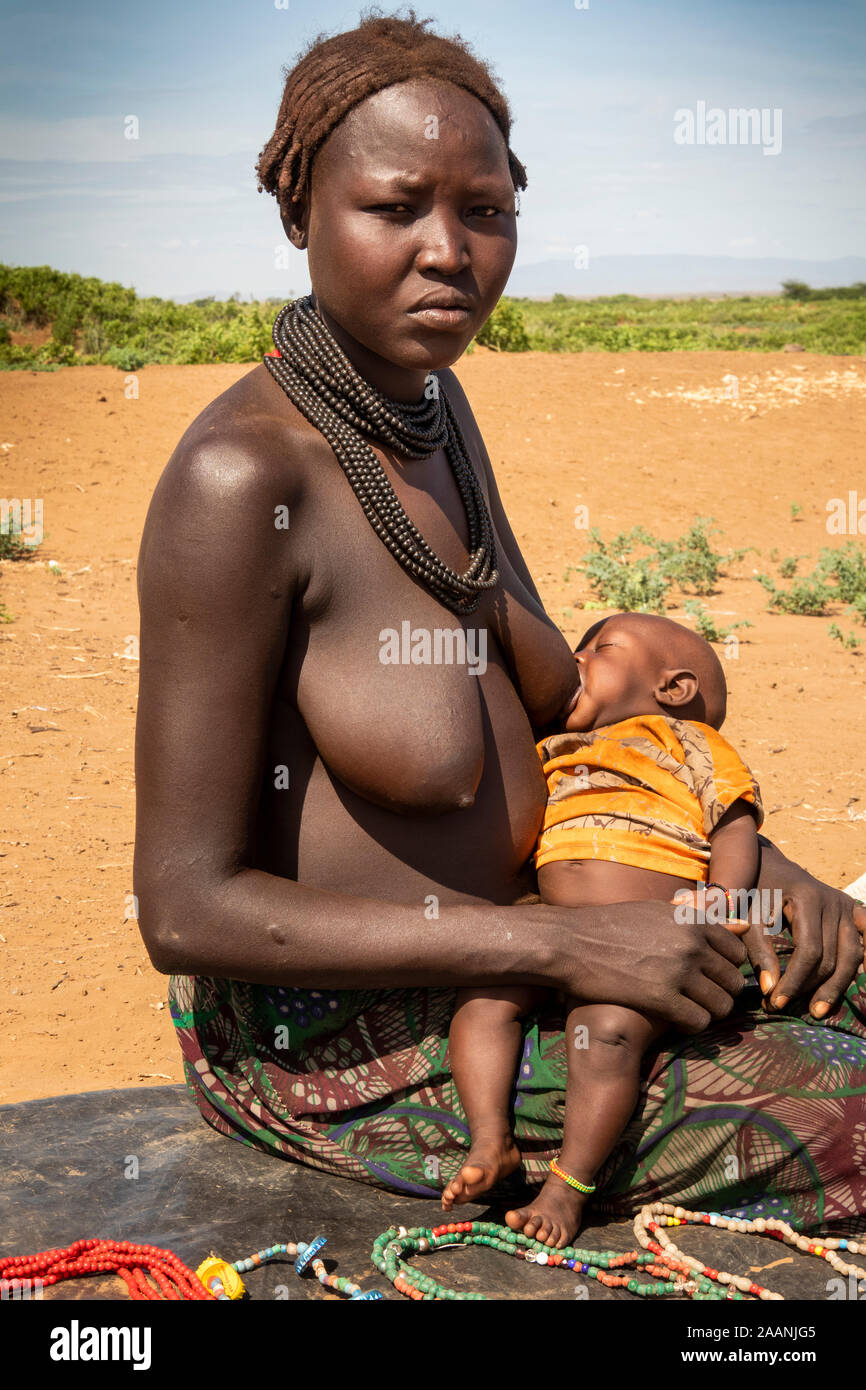 Ethiopia, South Omo, Omorate, Dasenech village, near Kenyan border, Dasenech tribal woman breastfeeding Stock Photo