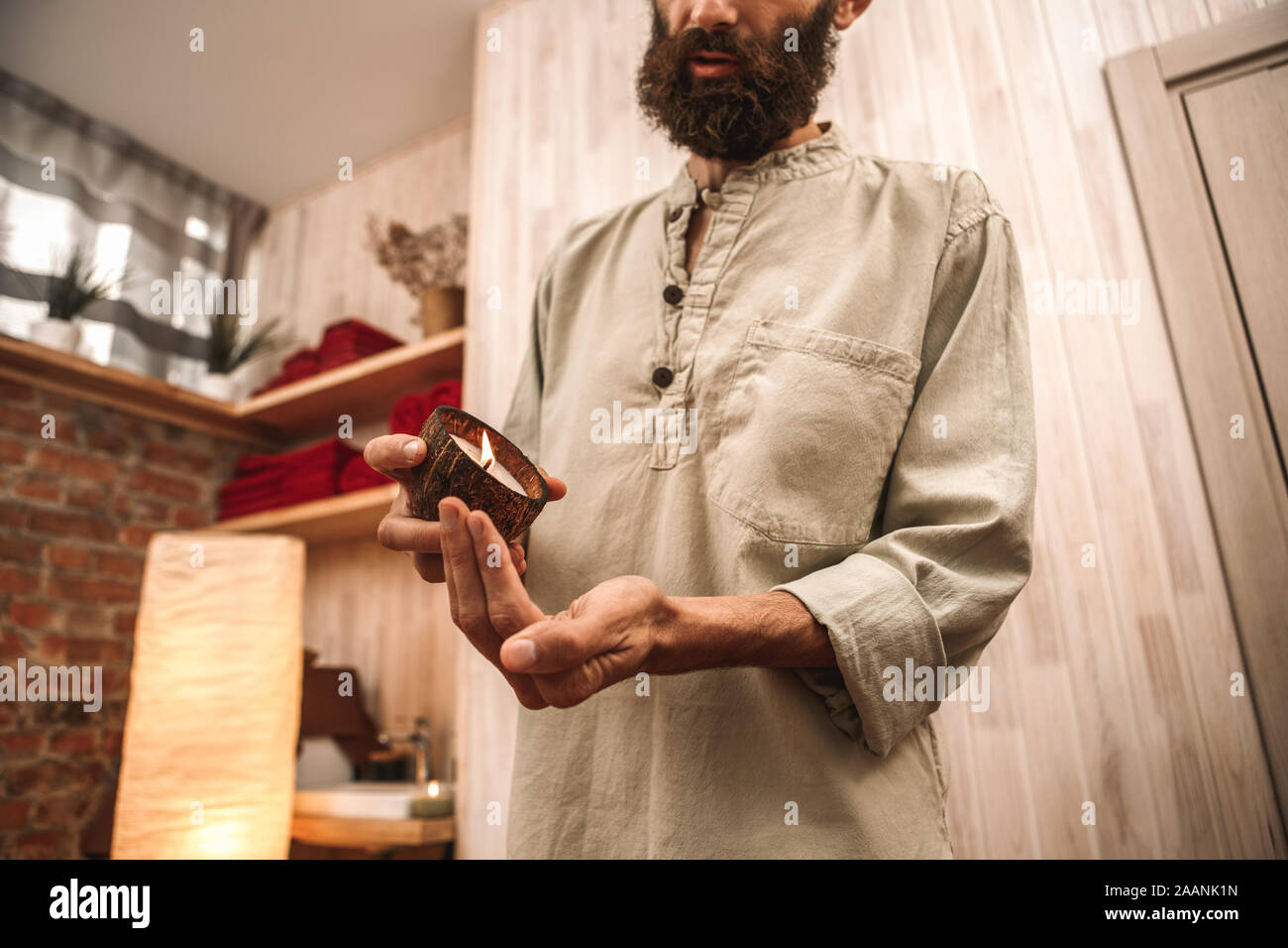 Alternative Medicine Healer Standing In Salon With Candle Pouring