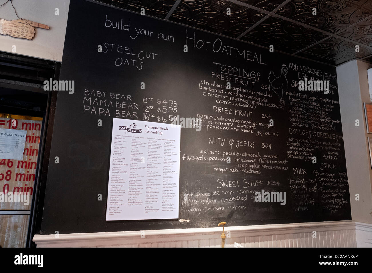 Printed and blackboard menus displayed inside OATMEALS restaurant, the world's first oatmeal bar. On West 3rd St. in Greenwich Village, Manhattan, NYC Stock Photo