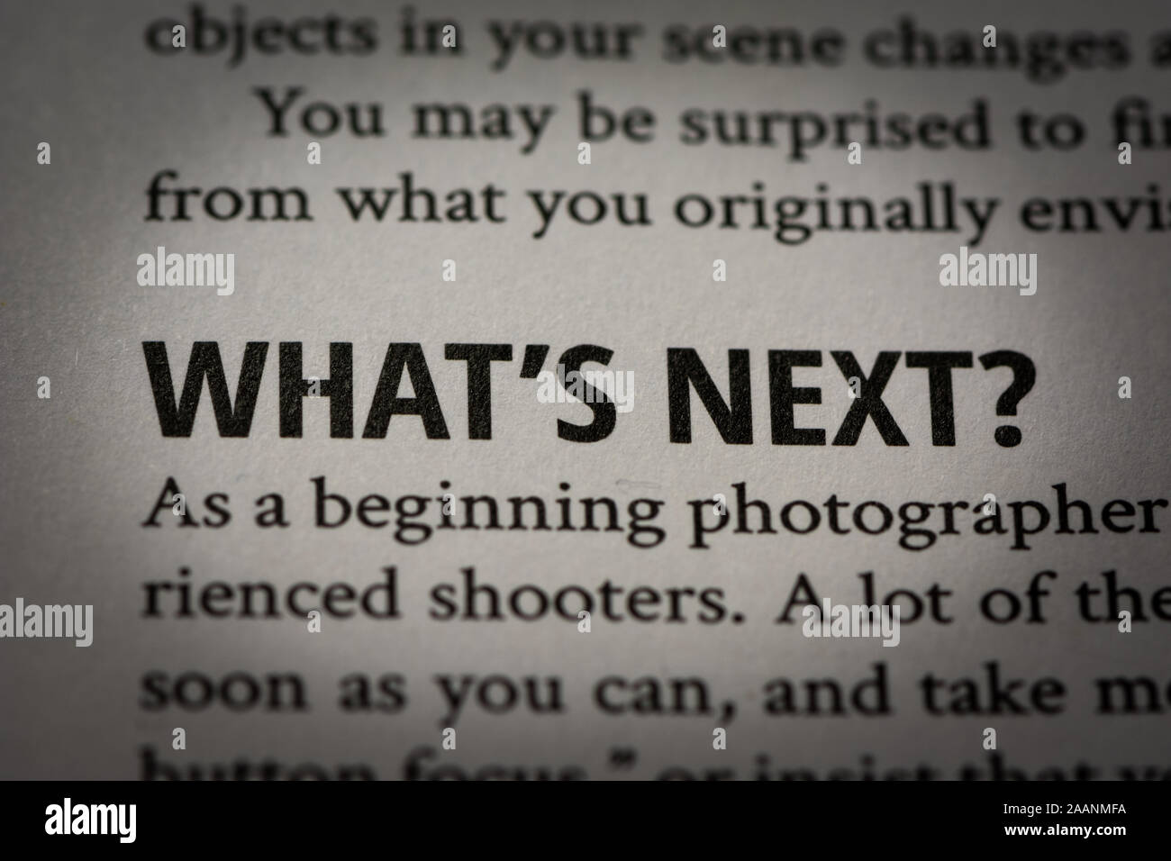 Macro photograph of question words 'What's next' in white page of a book about photography with small vignette applied. Stock Photo