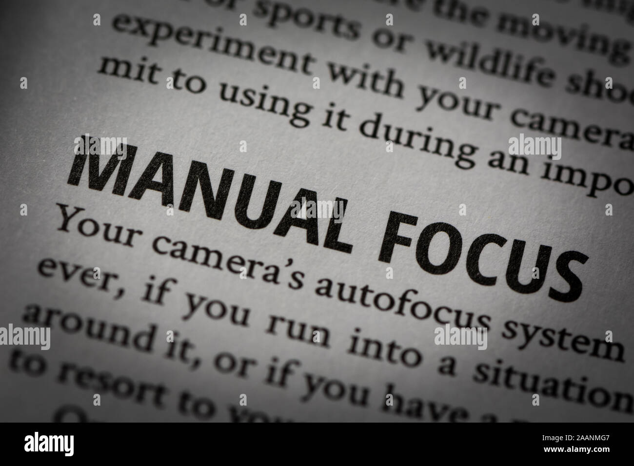 Macro photograph of words 'Manual focus' in white page of a book about photography with small vignette applied. Stock Photo