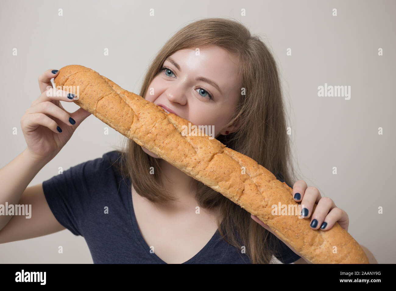 young-caucasian-woman-eats-french-baguette-2AANY9G.jpg