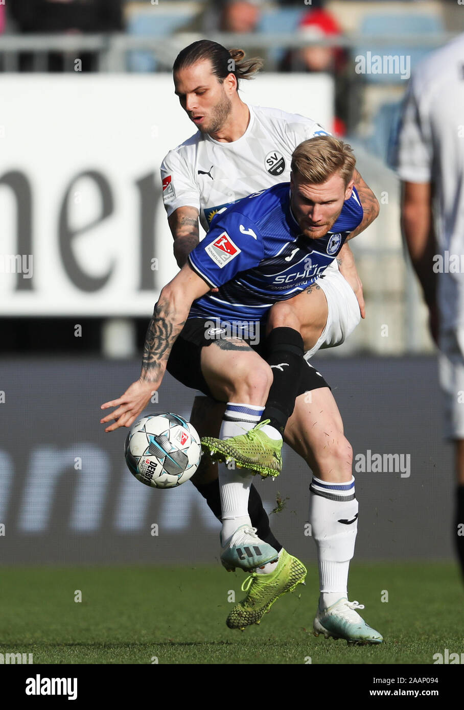 23 November 2019, North Rhine-Westphalia, Bielefeld: Soccer: 2nd Bundesliga, Arminia Bielefeld - SV Sandhausen, 14th matchday in the Schüco Arena. Bielefeld's Andreas Voglsammer (r) in the fight for the ball with Dennis Diekmeier (l) from Sandhausen. Photo: Friso Gentsch/dpa - IMPORTANT NOTE: In accordance with the requirements of the DFL Deutsche Fußball Liga or the DFB Deutscher Fußball-Bund, it is prohibited to use or have used photographs taken in the stadium and/or the match in the form of sequence images and/or video-like photo sequences. Stock Photo