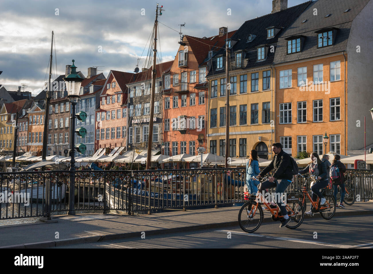 Copenhagen old town, view of people cycling across the Nyhavn bridge in the Old Town harbor district of Copenhagen, Denmark. Stock Photo