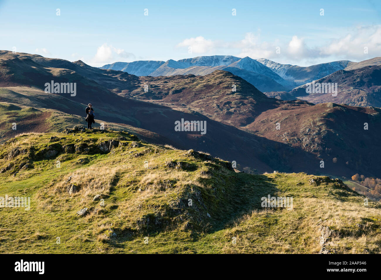 Epic Autumn Fall landscape of mountains and hills viewed from Hallin Fell on a crisp cold morning with stunning sunlgiht hitting the slopes Stock Photo