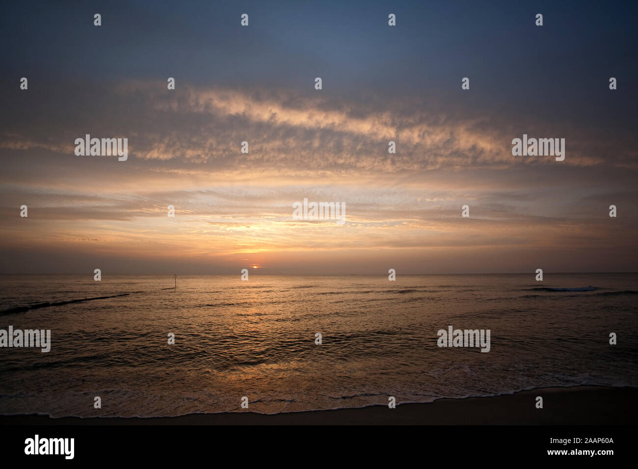 Abendsonne ueber dem Meer bei bewoelktem Himmel am Strand bei Wenningstedt auf Sylt Stock Photo