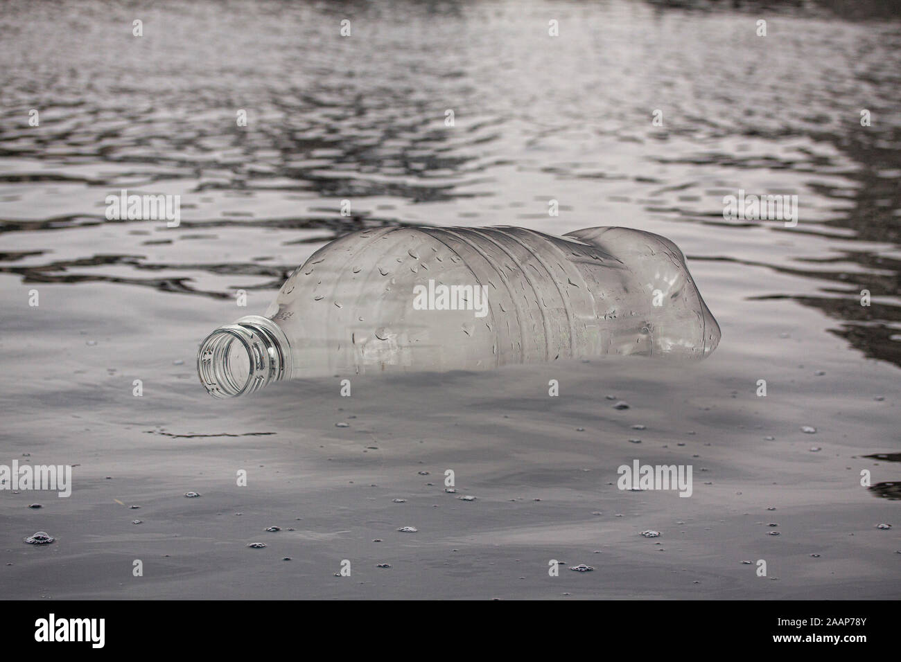 Empty plastic bottle floating in water. Pollution concept. Close up image. Stock Photo