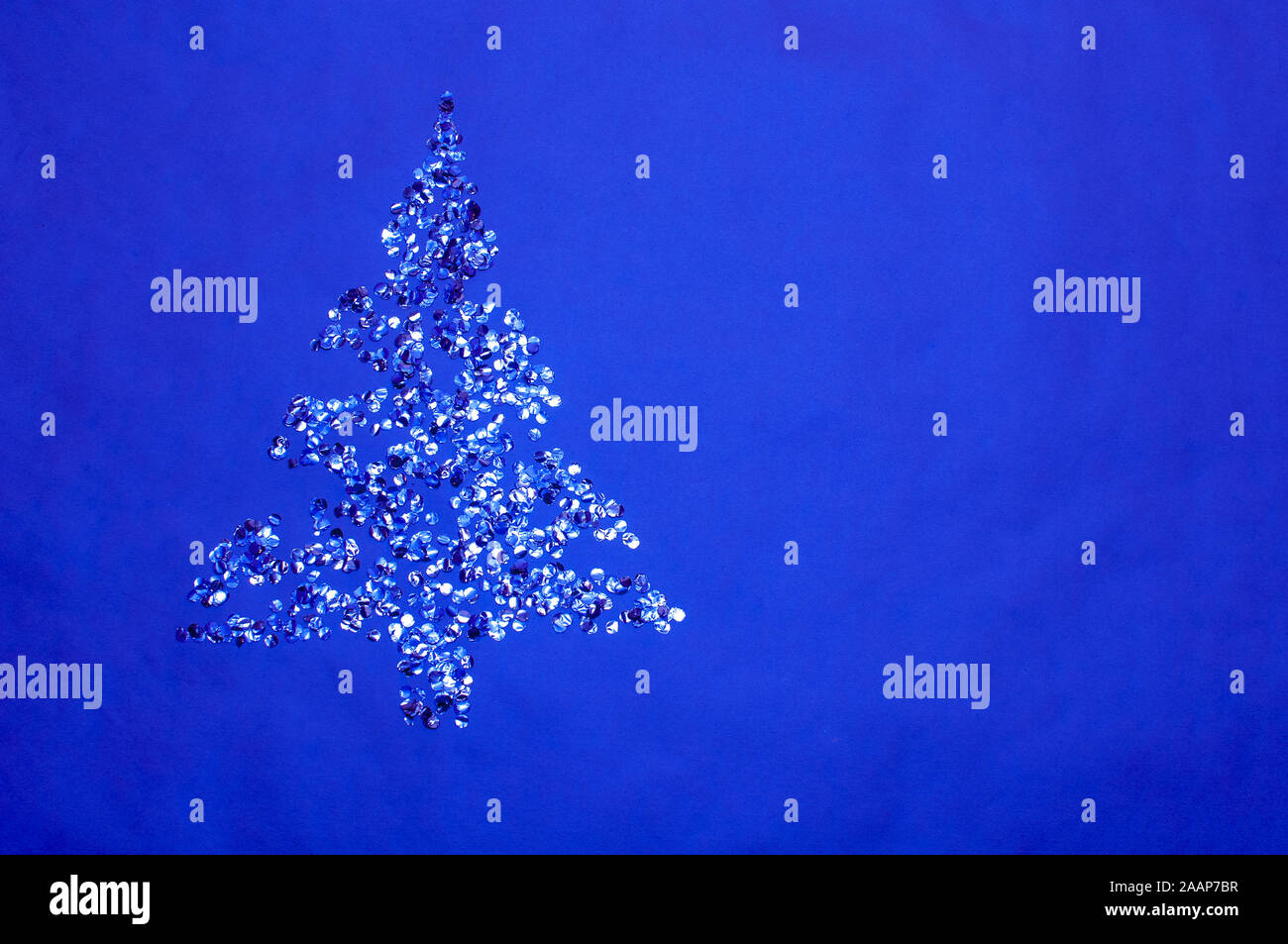 golden and silver shiny confetti lay against blue background Stock Photo
