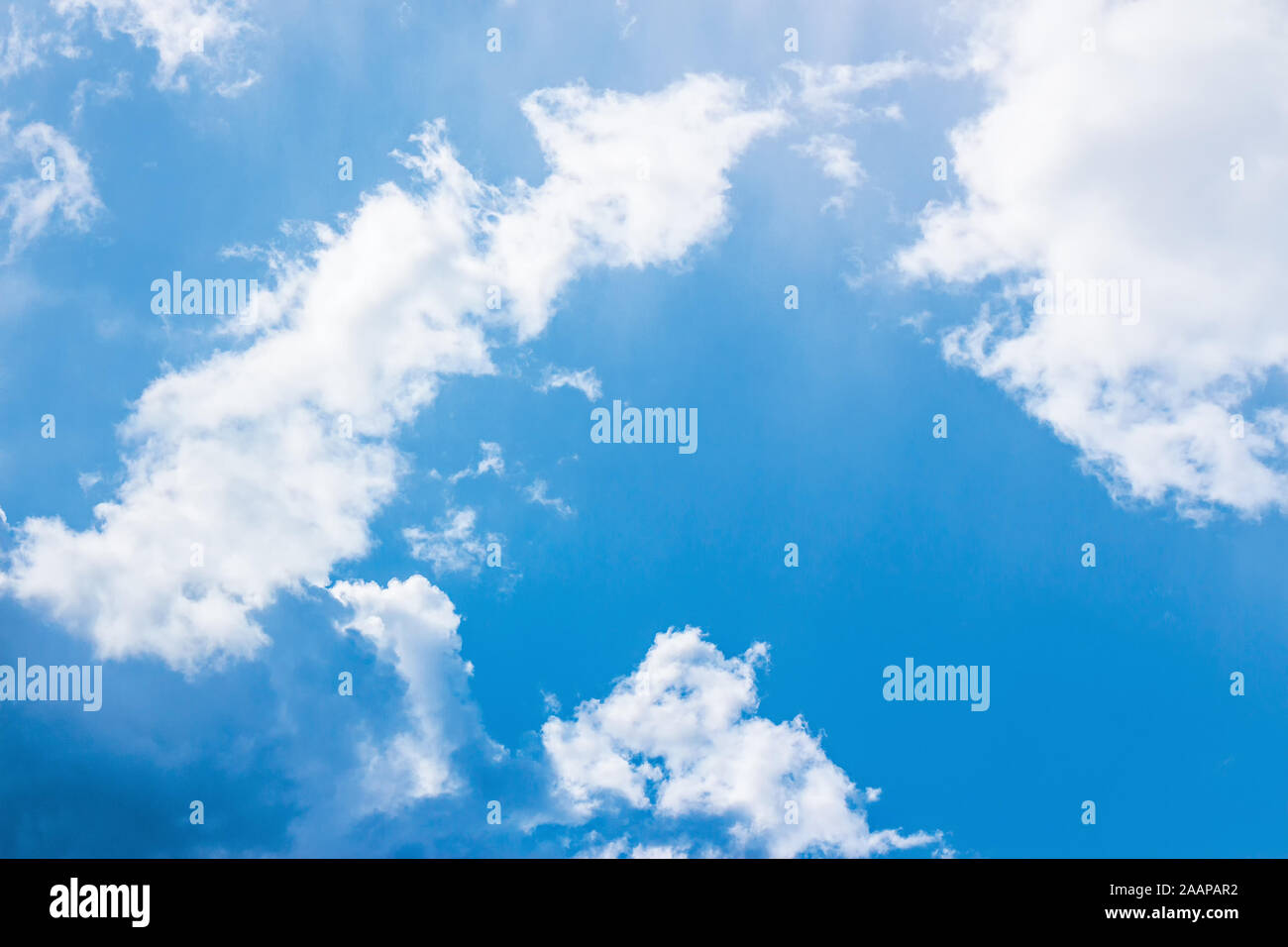 blue sky with puffy clouds. beautiful springtime nature background. dynamic side lit cloudscape Stock Photo