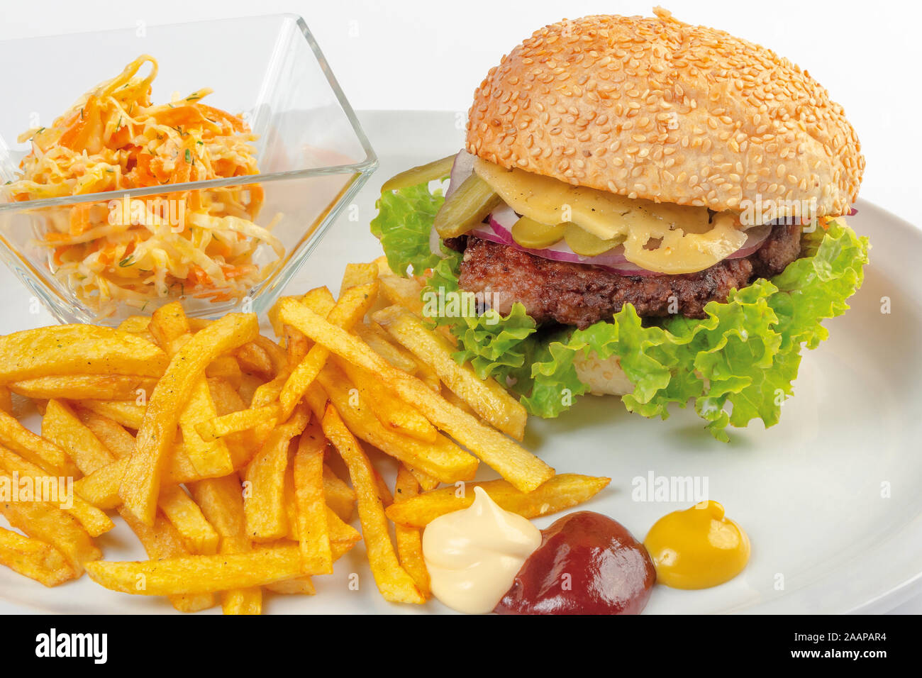 fast food menu. hamburger, french fries and salad. burger with beef stake, cheese onion and pickle. mayonnaise ketchup mustard on the white plate. hea Stock Photo