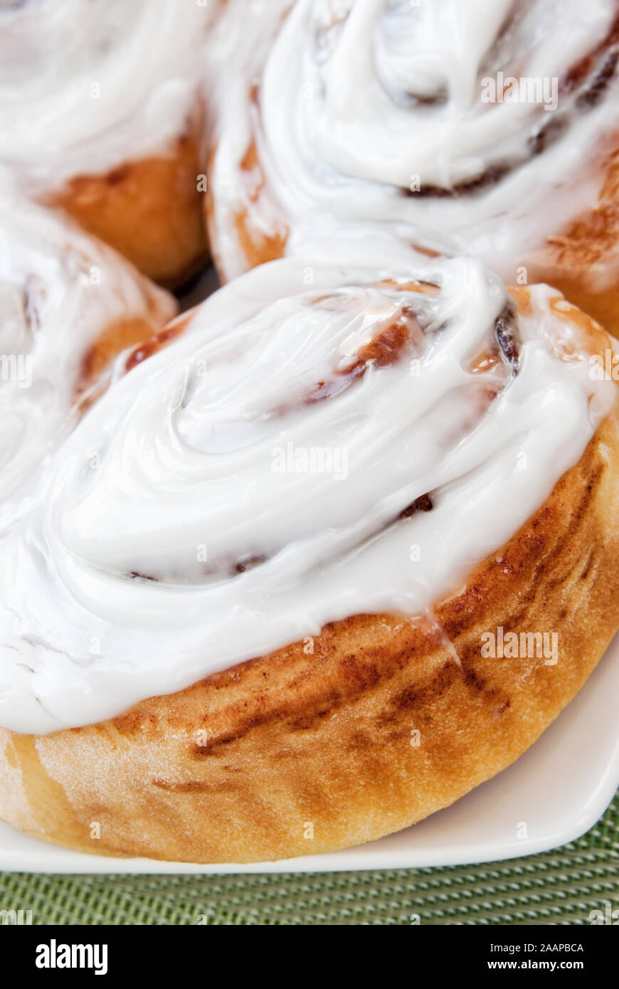 Homemade fresh cinnamon sticky buns with white glazed icing. Shallow