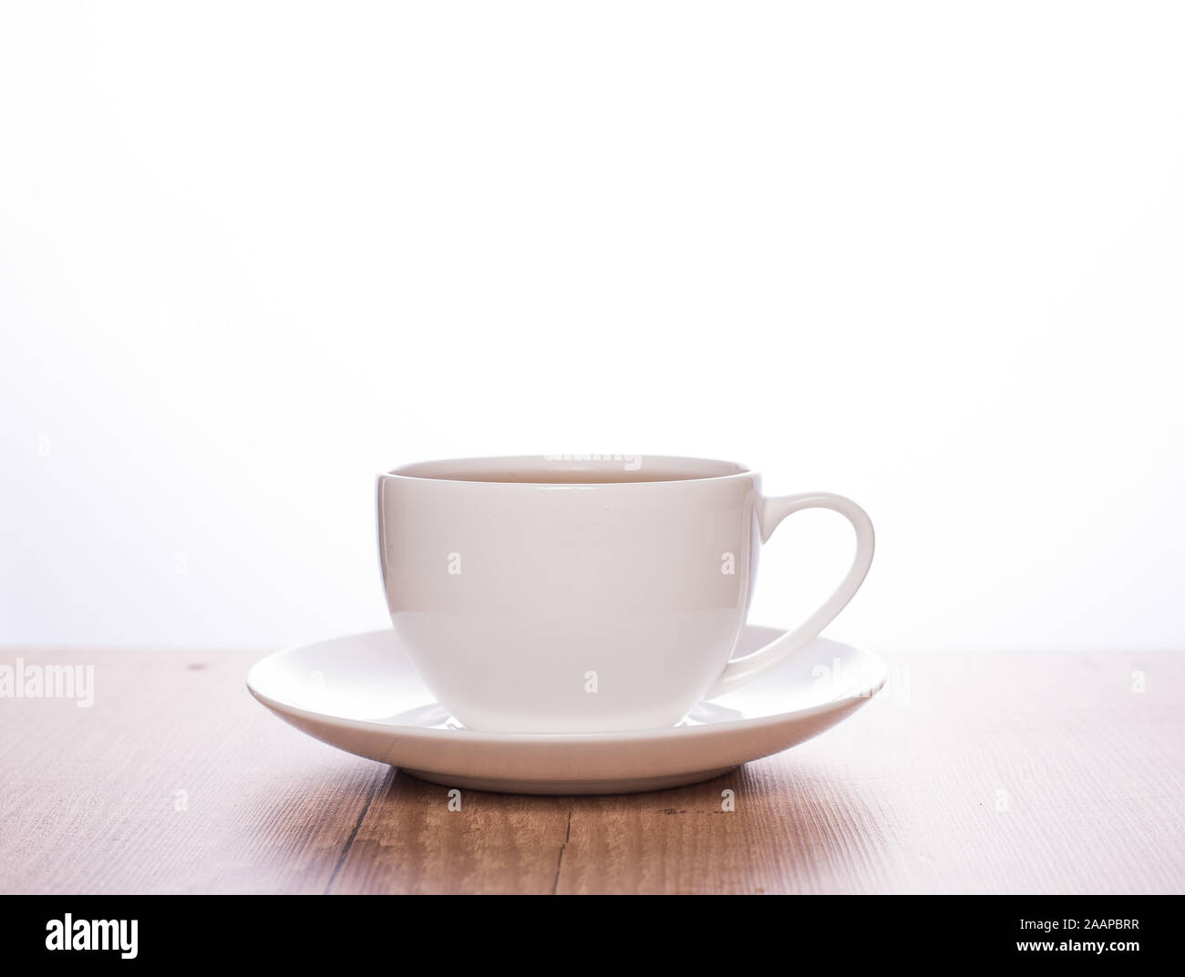 Plain white cup on a wooden table and white background (coffee, tea, espresso) Stock Photo