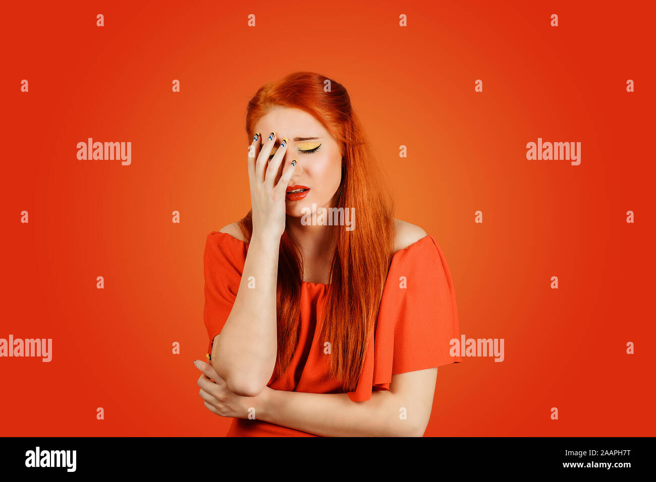 Stressed redhead woman about to cry, depressed wearing red dress with long ginger  hair isolated on red background Stock Photo - Alamy