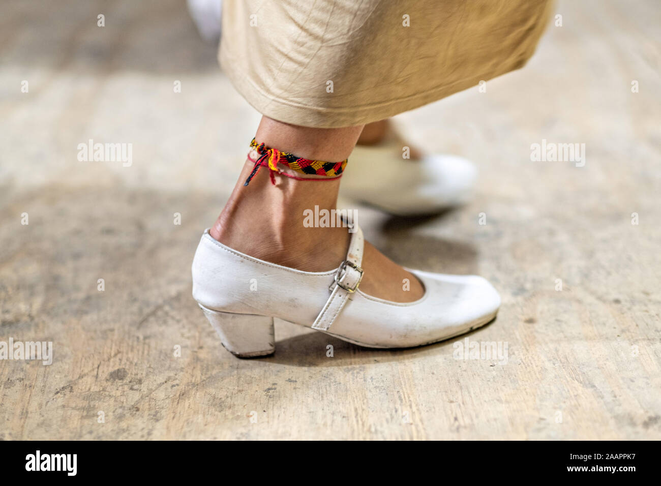 Zapateado dancers perform a traditional folk dance during a neighborhood Huapango in Santiago Tuxtla, Veracruz, Mexico. The dance involves dancers striking their shoes on a wooden platform while a large group of musicians play string instruments. The gatherings take part in the Los Tuxtlas mountain villages for single people to meet. Stock Photo