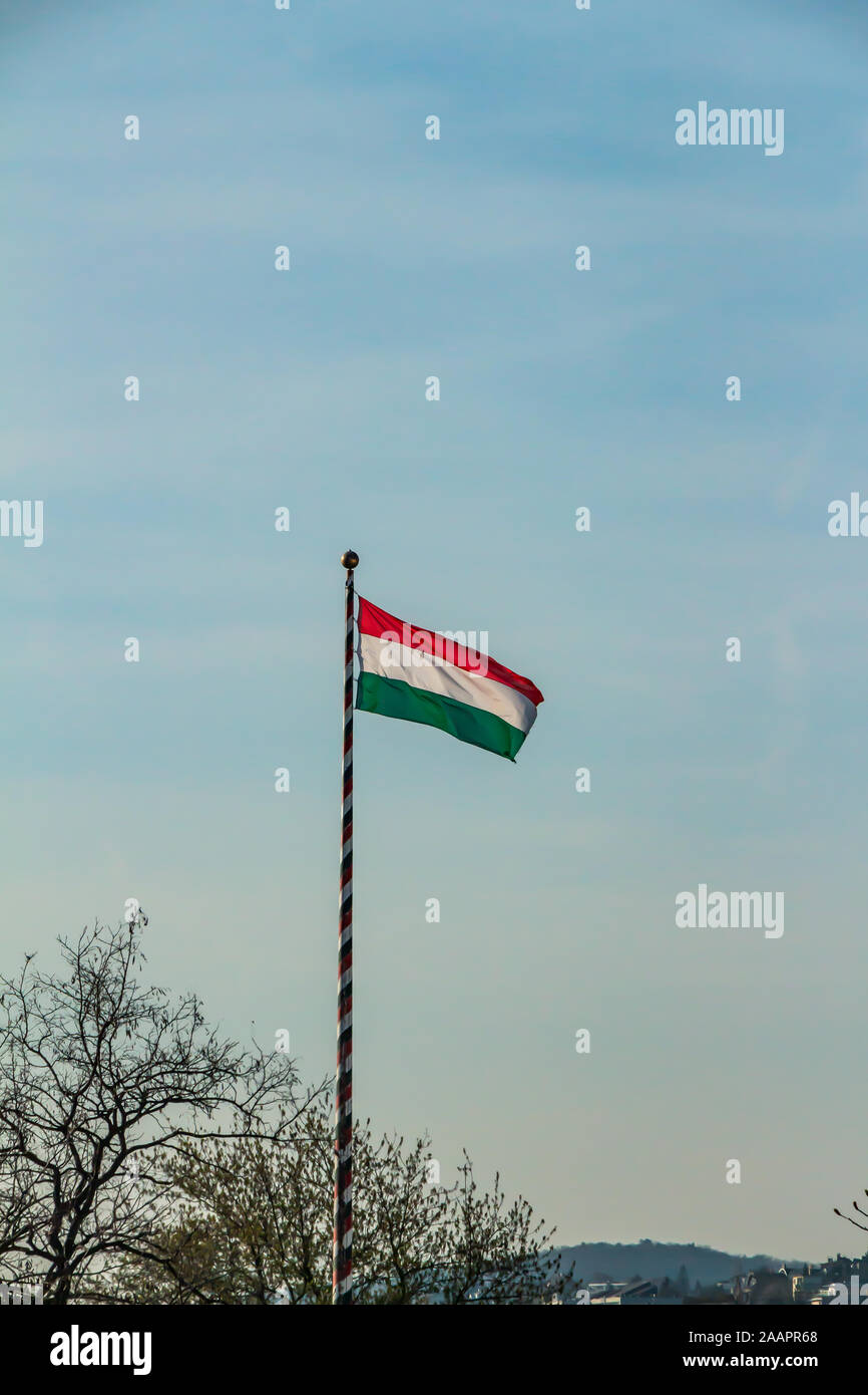 Hungary, Hungarian national flag waving on blue sky background Stock Photo