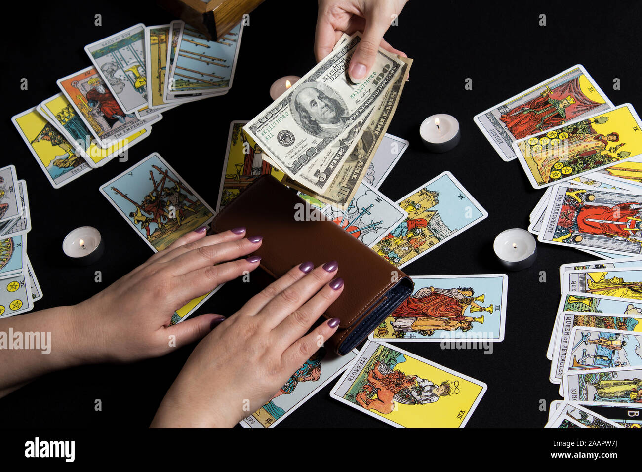 New York, USA. November 22.19. Hands holding cash dollar on background of  wallet and Tarot cards. Payment for esoteric, magical and witchcraft  service Stock Photo - Alamy