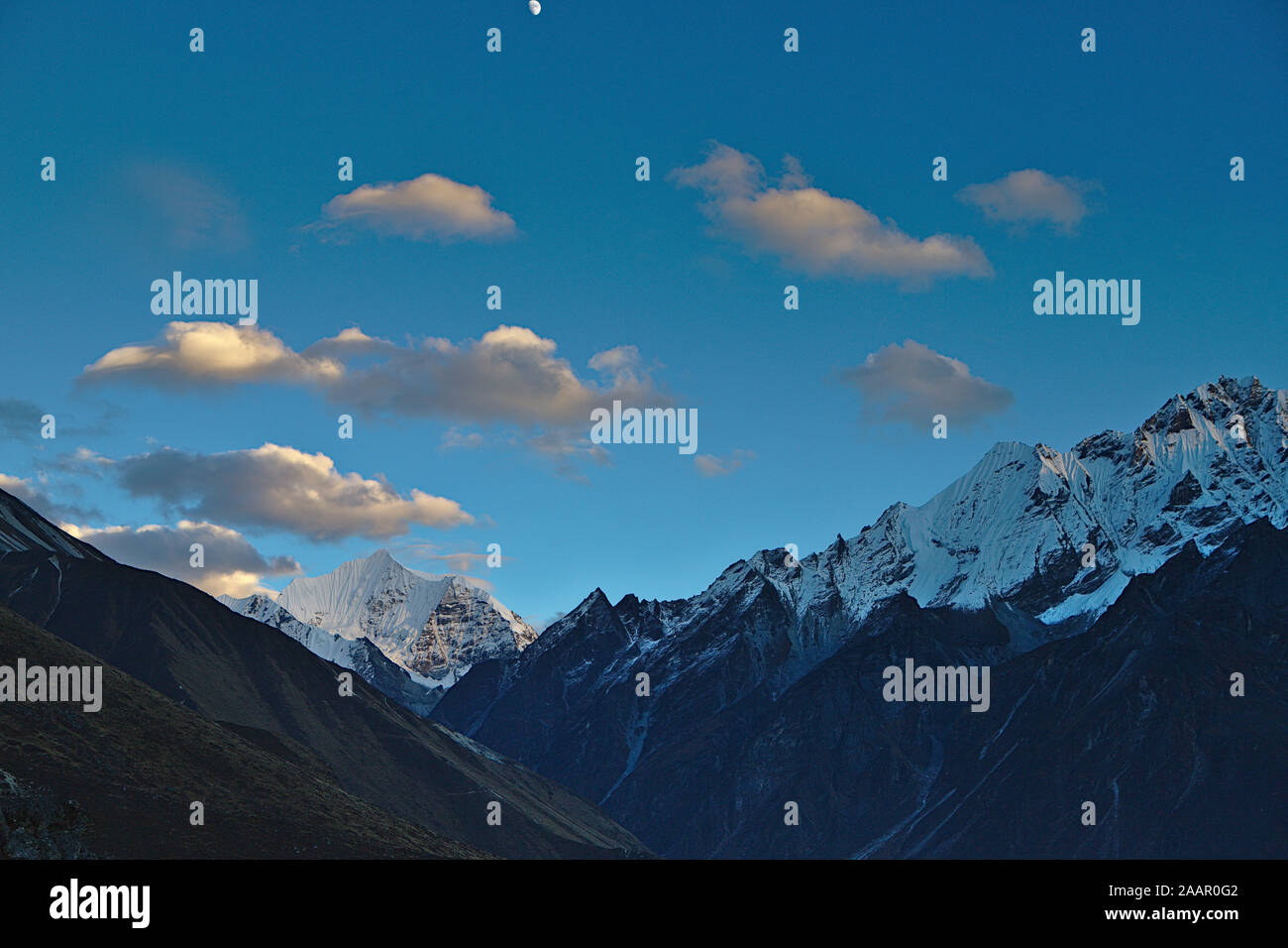 blue skies with creamy clouds and snow capped peaks Stock Photo