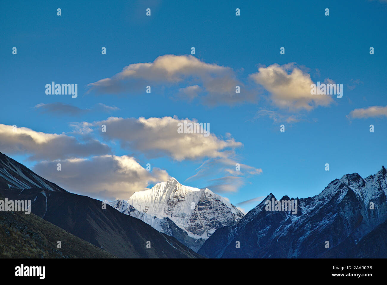 blue skies with creamy clouds and snow capped peaks Stock Photo
