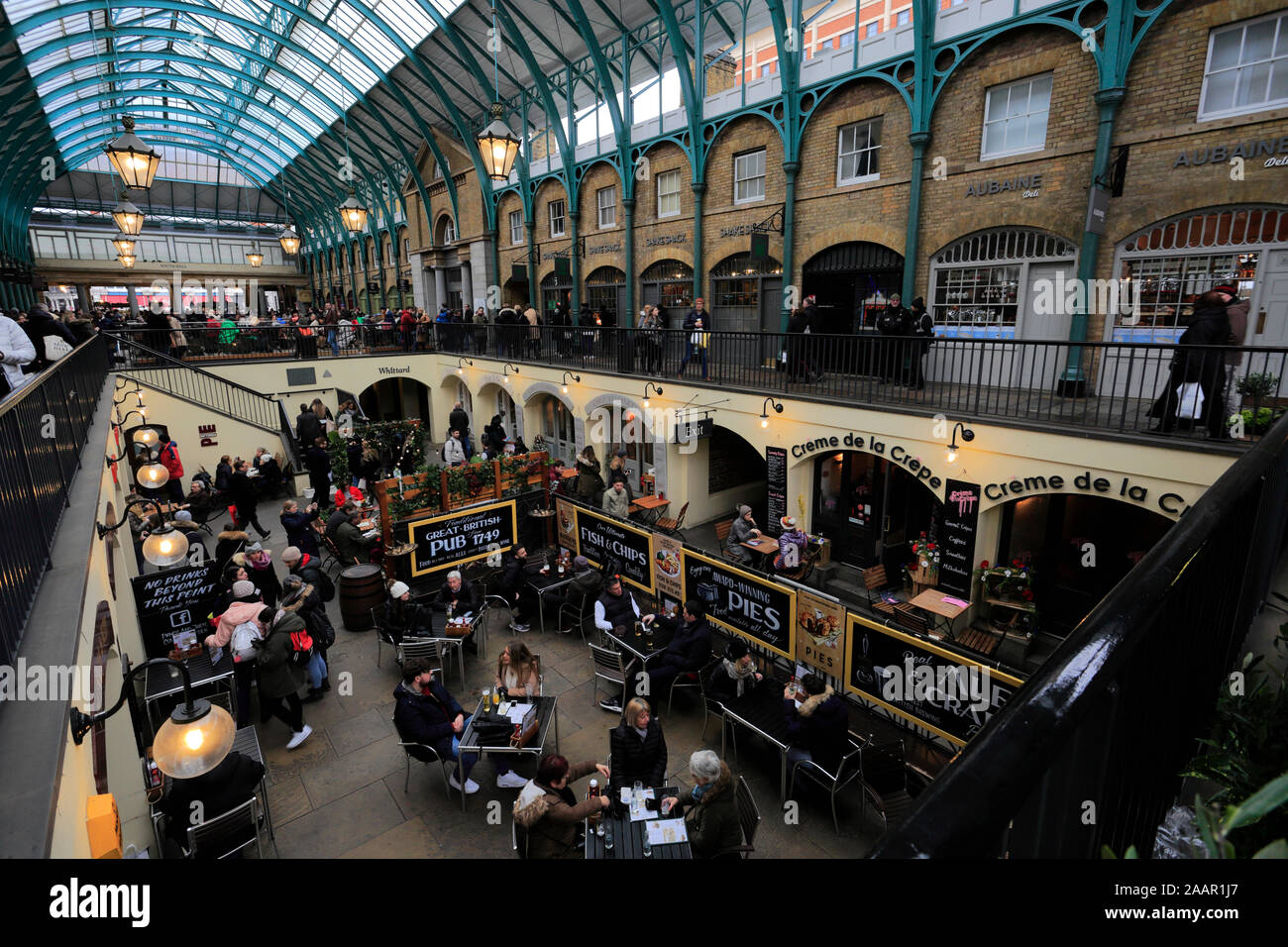 Christmas lights and busy Christmas market stalls inside Covent Garden ...