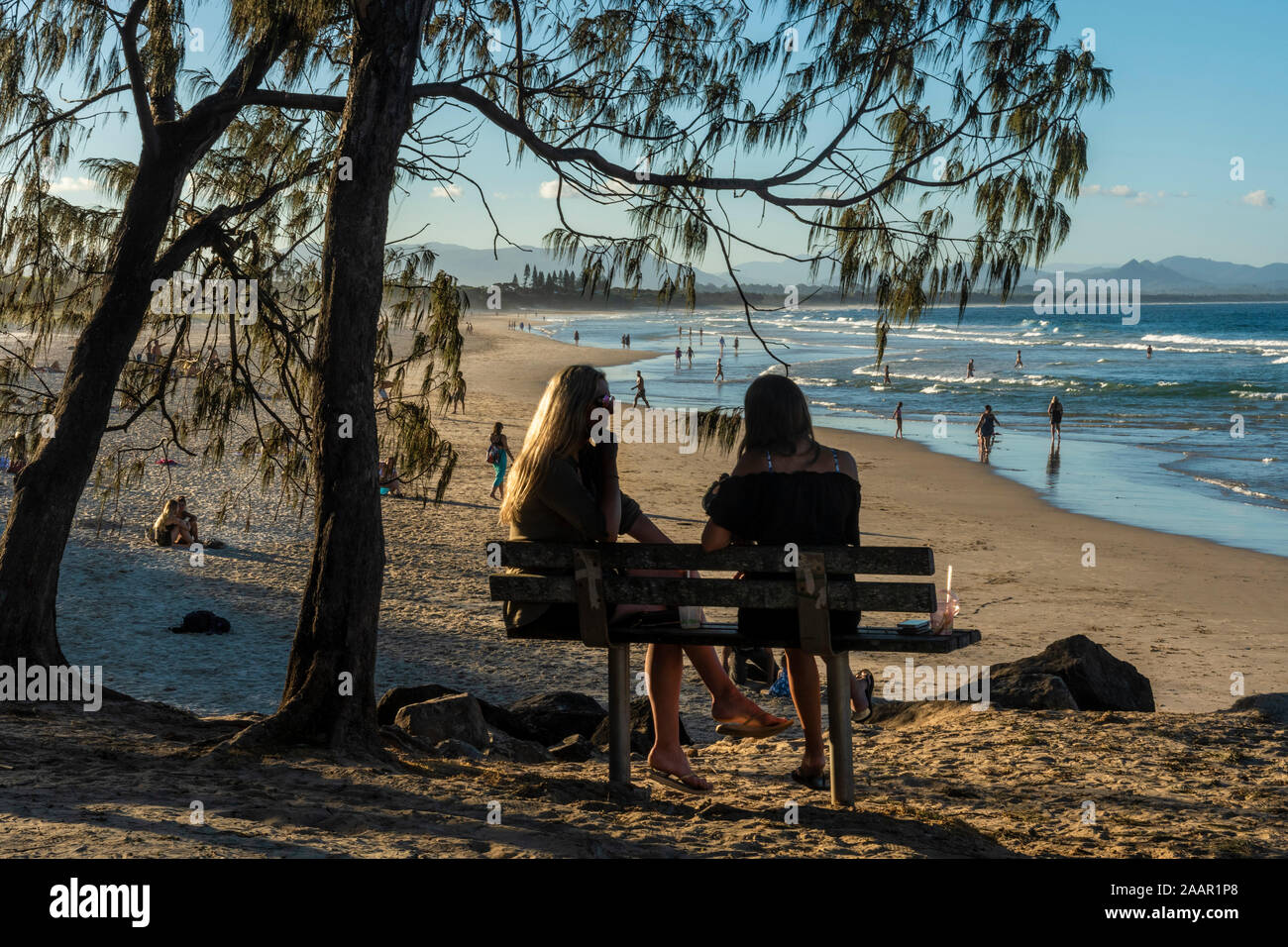 Girls hanging out chatting by beach, Byron Bay Stock Photo