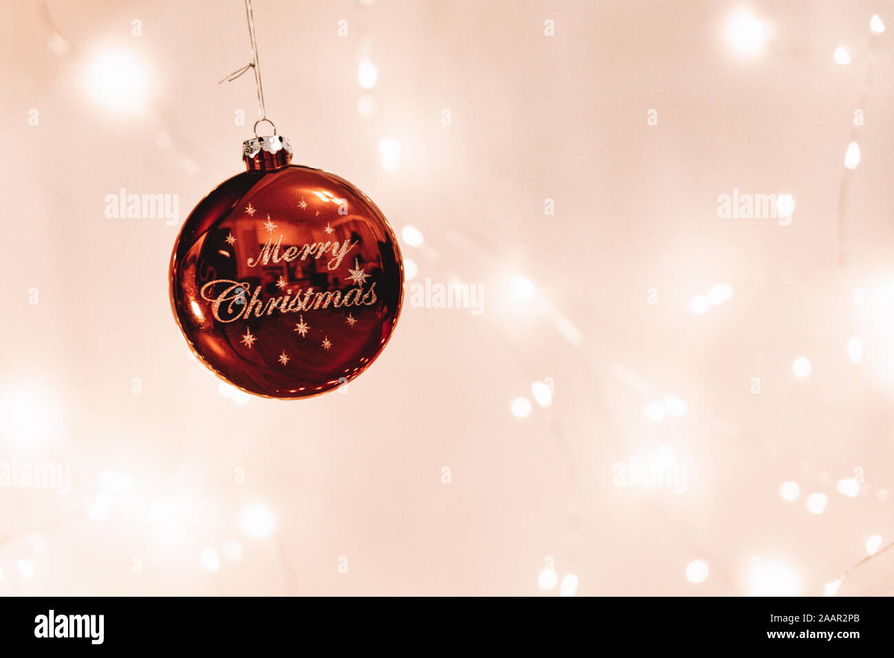 A 'Merry Christmas' Decoration with lights in the background Stock Photo