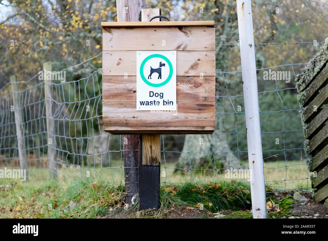 Wooden dog poo box bin on post in rural location to keep the