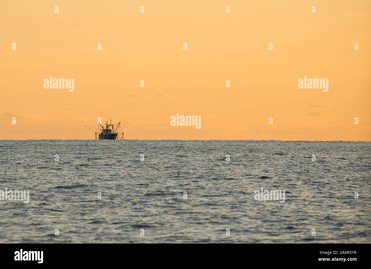 A beam trawler in the evening lowering its nets in the English Channel off the Devon coast. Devon England UK GB Stock Photo