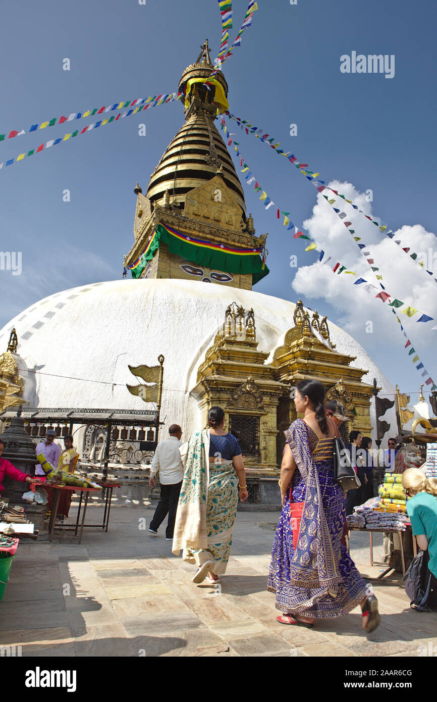 People walking with white dome of temple Stock Photo
