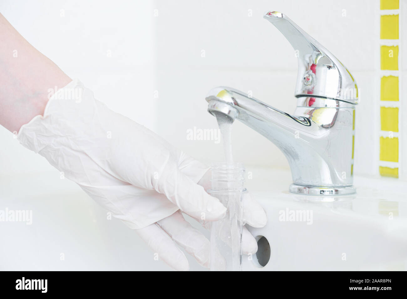 Tap water analysis quality control concept. Hand with a flask and water