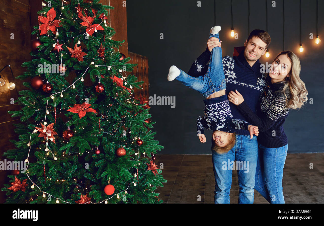 Funny family laughing in a room with a Christmas tree. Stock Photo