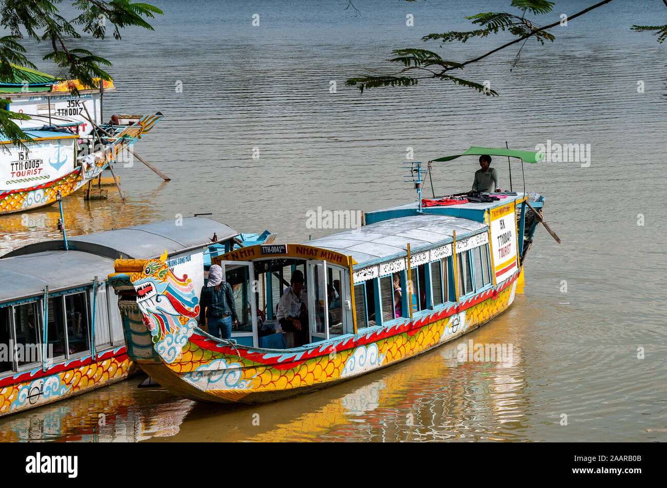 Colorful boats are used by tourists to get to the Pagoda of the Celestial Lady on the Perfume River, near Hue, Vietnam Stock Photo