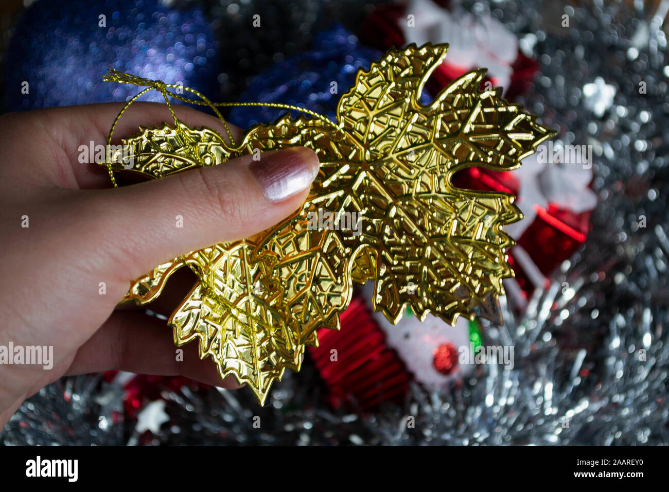 Close up of hand holding Maple Leaf Christmas decoration, photo-illustration Stock Photo