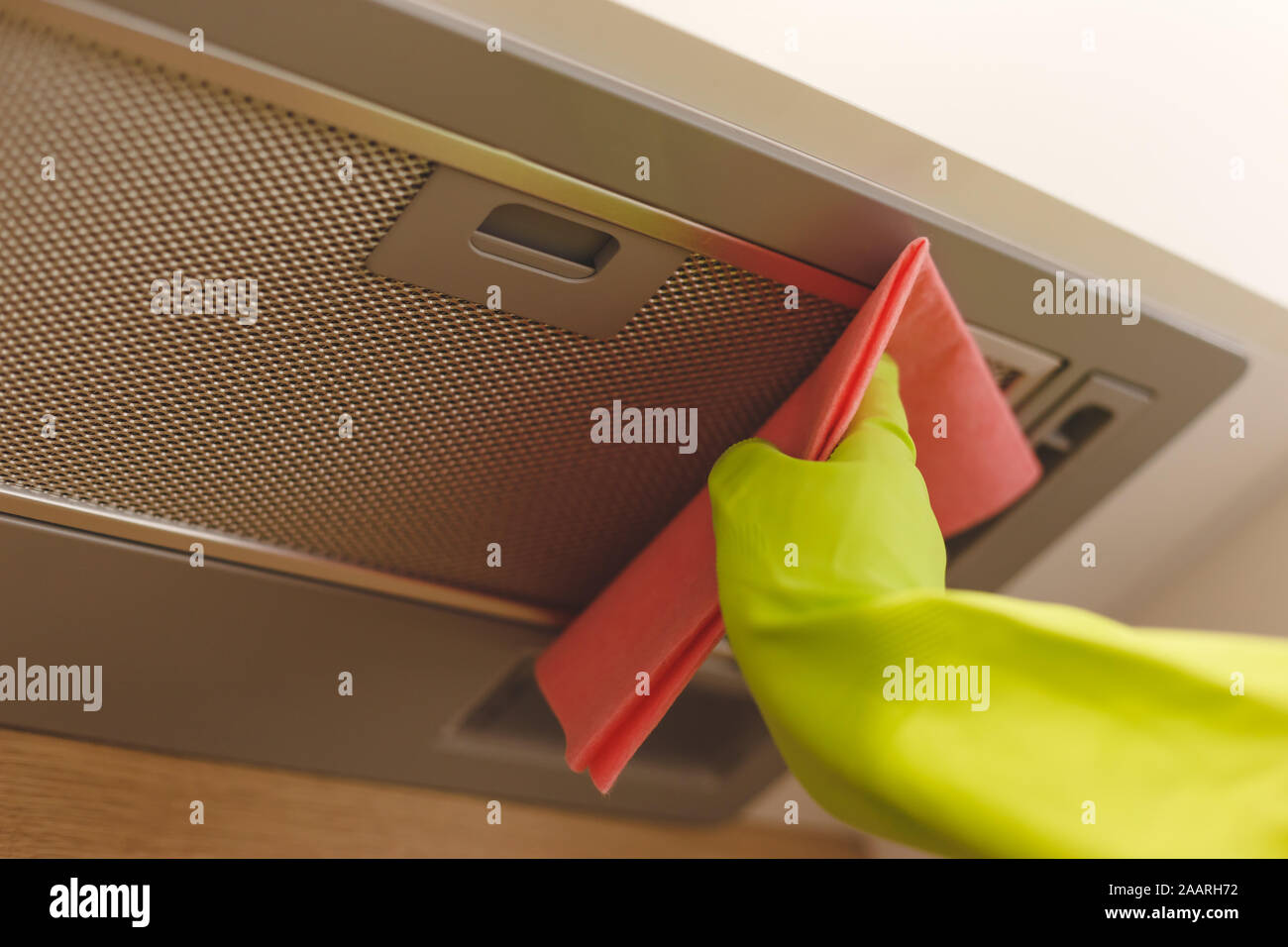 Cleaning domestic cooker hood grid with pink cloth fiber napkin Stock