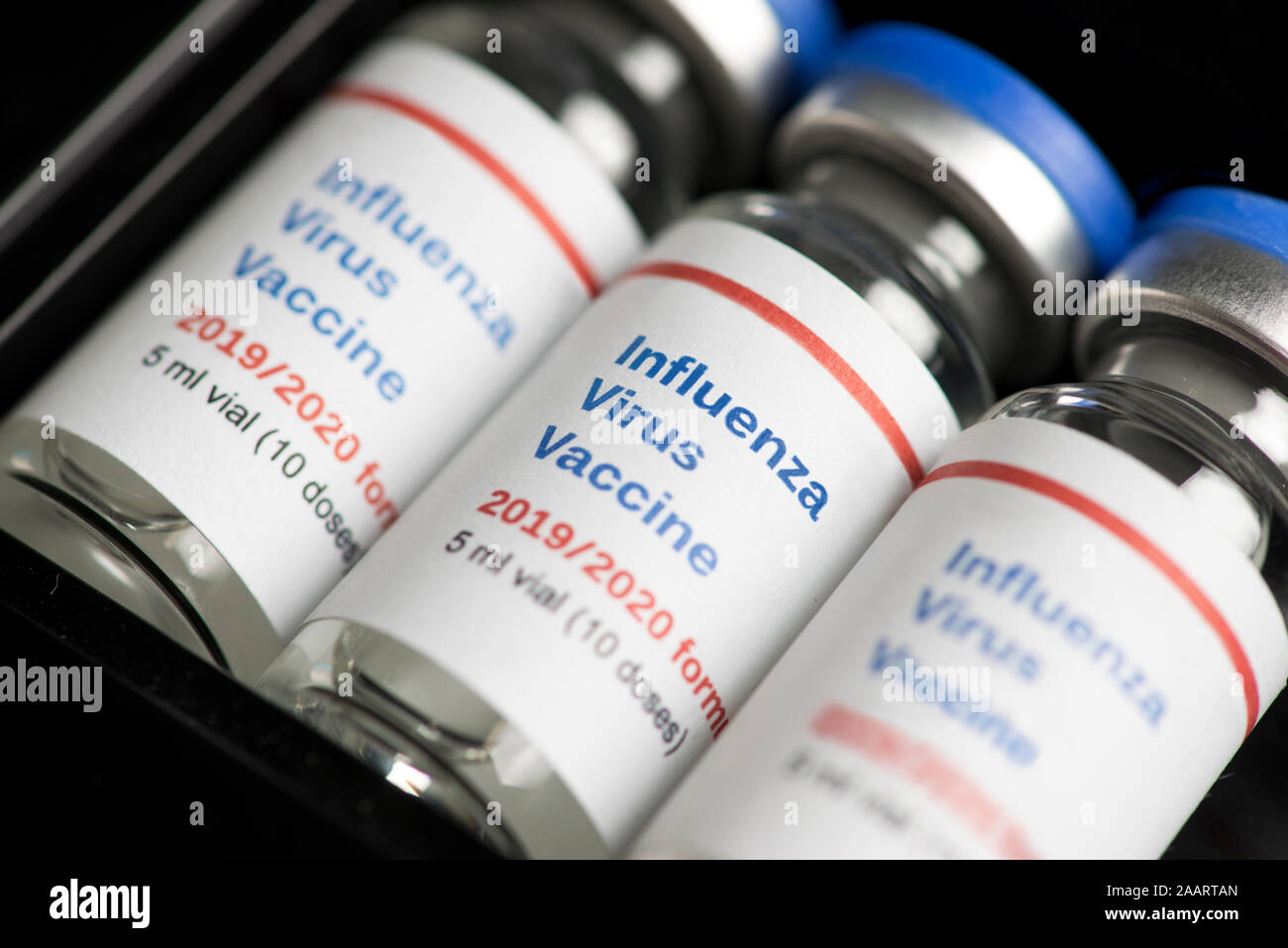 Multiple Influenza Flu Virus vaccine vials in packaging container. Stock Photo